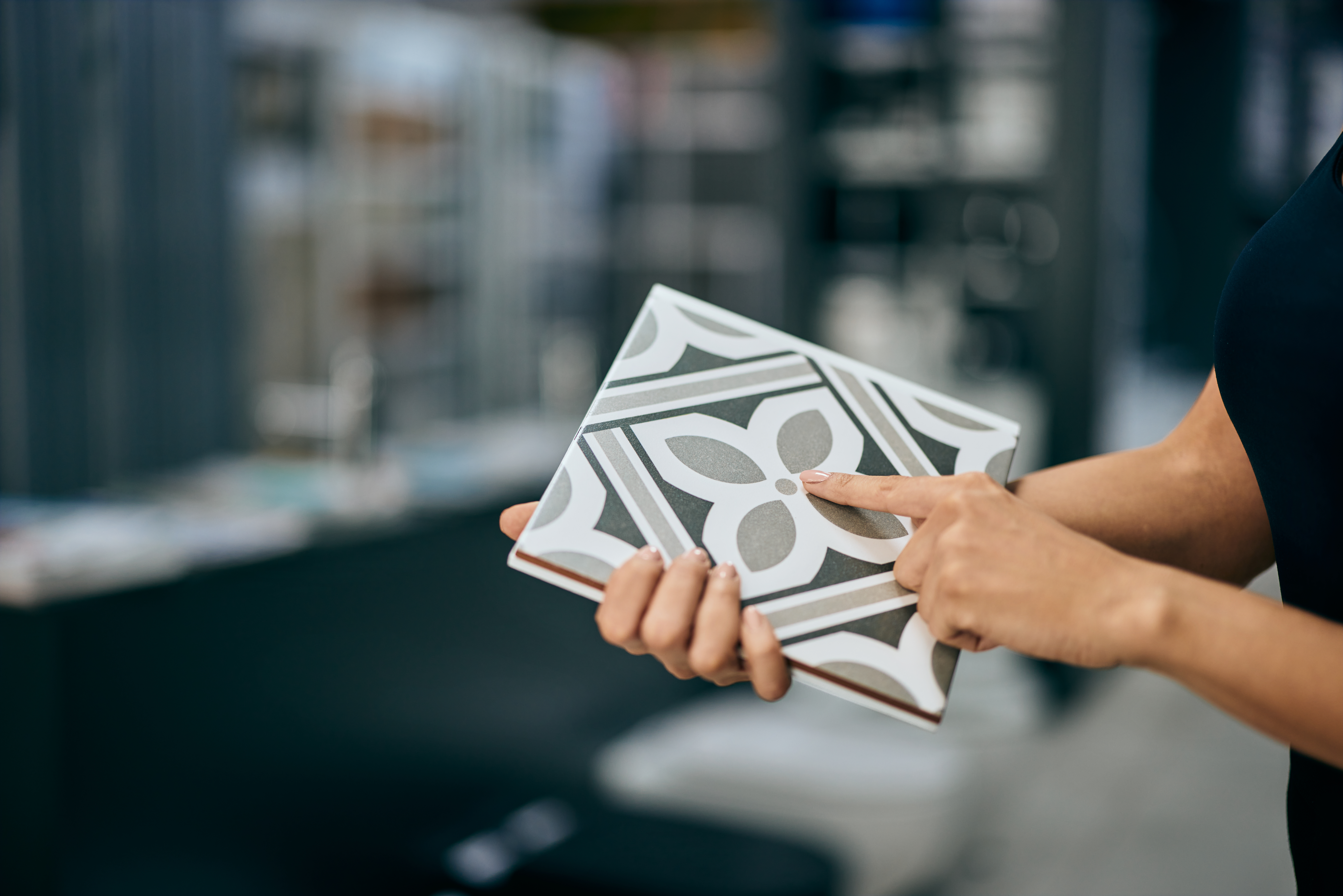 Female Hands Holding A Ceramic Tile, Looking At The Design On It